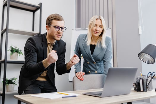 Concentrated male businessman looking at computer monitor, working with a young female worker on a project, people holding a meeting with a client or interviewing a job candidate. photo