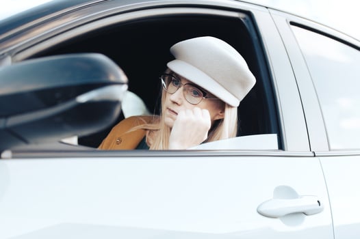 Middle-aged woman driver driving a car. Pretty female with hat and glasses, transport concept photo