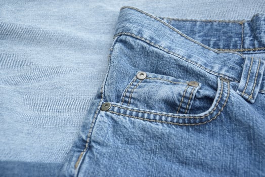 Lots of jeans pants in a stack. Denim background. photo