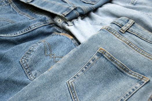 Lots of jeans pants in a stack. Denim background. photo