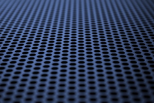 Industrial background. Deep blue metal surface with regular round holes photo