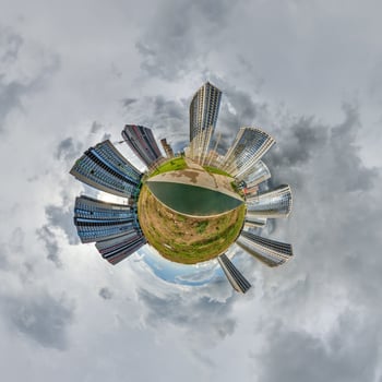 abstract swirling tiny planet spherical panorama of multi-storey buildings of skyscrapers of a residential complex in the form of a butterfly, bugs, crabs in sky with clouds photo
