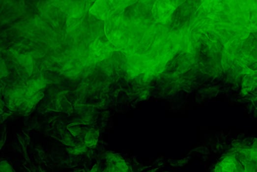 Circular Green Smoke Plume Against Dark Background photo