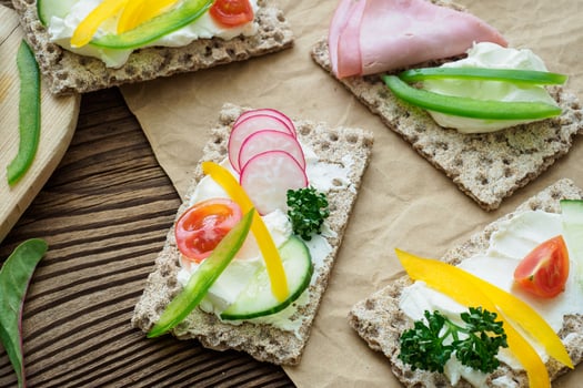Healthy sandwiches with fresh vegetables. Breakfast toasts on wooden cutting board. Balanced breakfast. photo