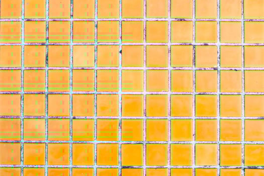 Texture of yellow mosaic tiles, close-up photo