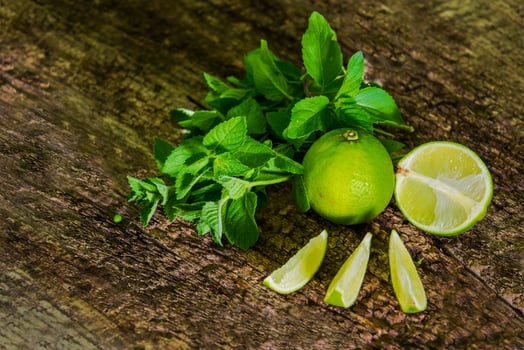 Fresh citrus lime with mint close up on wooden background. Mojito photo