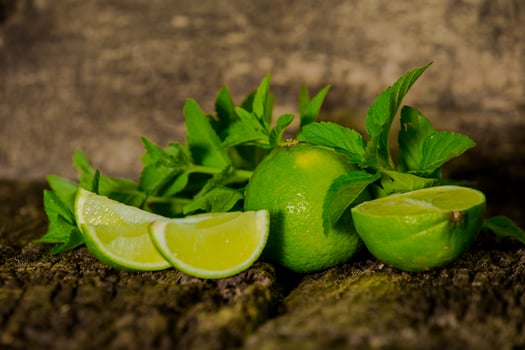 Lime with green mint leaves on a wood background photo
