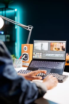 Black woman working at her desk, using a laptop and typing on the keyboard. She is immersed in her work, browsing and editing content, showcasing her creativity and productivity. photo