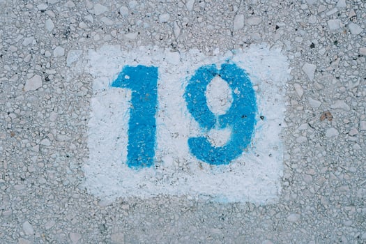 Number nineteen painted on the asphalt in a white rectangle photo