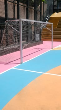 Colourful pink, blue, orange, soccer field and sport standsin the urban town with building background photo