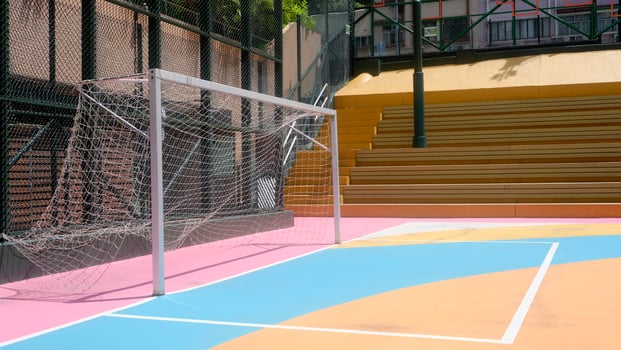 Colourful pink, blue, orange, soccer field and sport standsin the urban town with building background photo