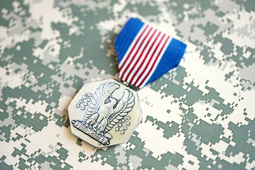 KYIV, UKRAINE - JULY 10, 2024 US Non-Combat Heroism Soldiers medal. United States military award medal with ribbon and pin. Handmade paper theater props photo