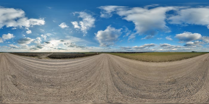 hdri 360 panorama on gravel road among fields in spring evening with awesome clouds in equirectangular full seamless spherical projection, for VR AR virtual reality content photo