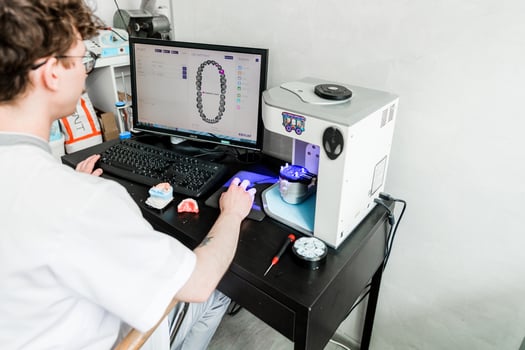 Dental Technician Analyzing Tooth Models on Computer. Minsk, Belarus- October 15, 2023 photo