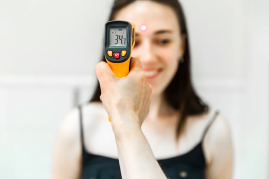 Infrared Thermometer Displaying Temperature During Check on Woman photo