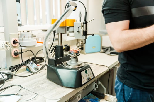 Dental laboratory machine with technician operating equipment photo