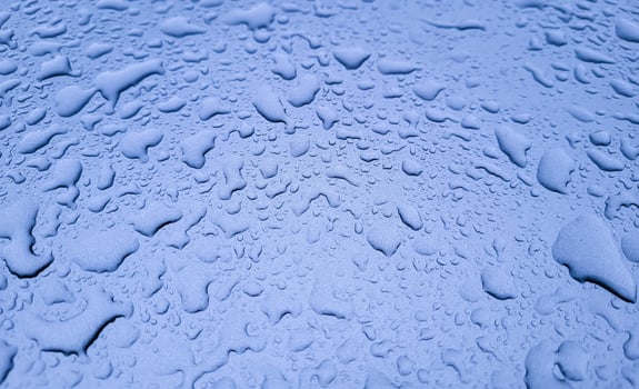 Large raindrops on the lilac hood of the car photo