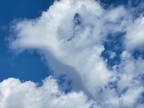 Fluffy white clouds and blue sky on a beautiful clear day photo