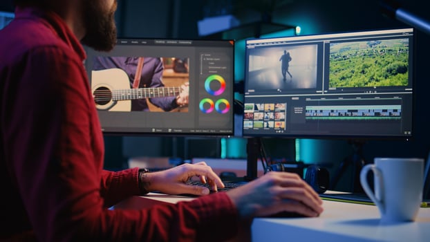 editor working for independent production company inputting music, dialogues, graphics and effects over raw footage. Videographer in creative multimedia agency editing clips photo