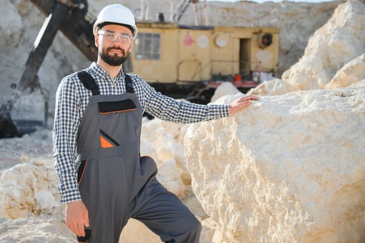 Worker in hardhat standing in stone quarry photo