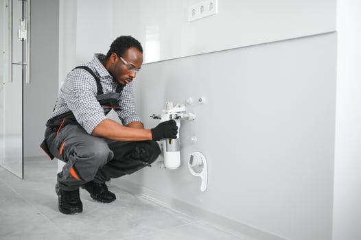 African american plumber change the water filter. photo