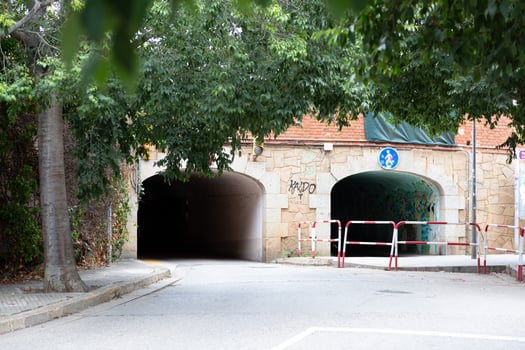 Two pedestrian tunnels under a road passing under a building photo