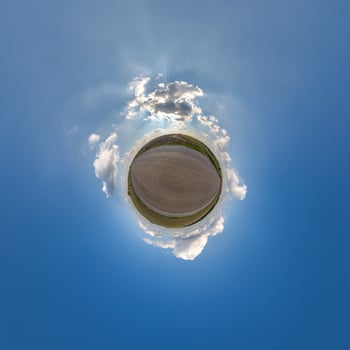 simple little tiny planet without buildings in blue sky with beautiful clouds. Transformation of spherical panorama 360 degrees. Spherical abstract aerial view. Curvature of space. photo