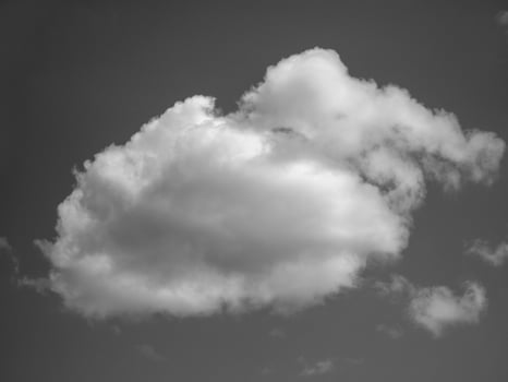 White fluffy cloud over blue summer sky background. Black and white photo background