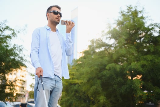 Blind man. Visually impaired man with walking stick, photo