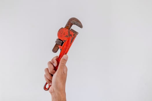 Hand holding a pipe wrench on a white background photo