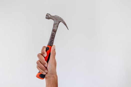 Hand holding a hammer on a white background photo