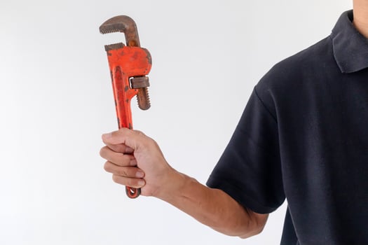 Man holding a pipe wrench on a white background photo