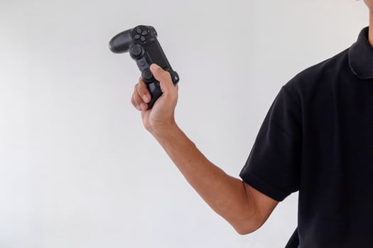 Man holding a gamepad controller or joystick on a white background photo