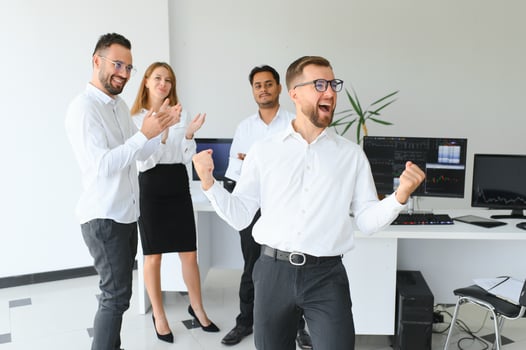 Team leader stands with coworkers in background photo