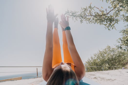 Woman in Orange Sportswear Doing Yoga Outdoors photo