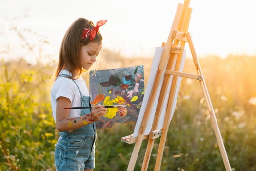 Little Girl Is Painting Picture Outdoors. photo