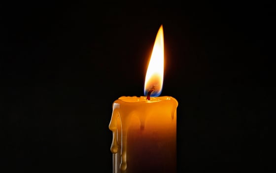 one burning candle with dripping wax close-up photo