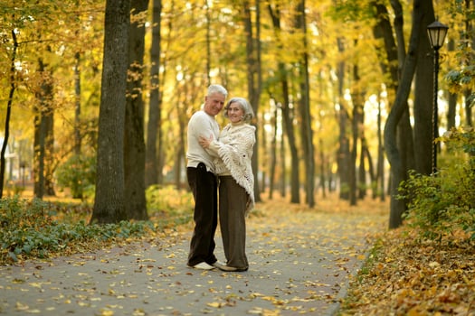 Mature couple walking in the autumn park photo