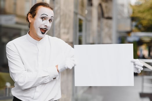 Your text here. Actor mime holding empty white letter. Colorful portrait with gray background. April fools day photo