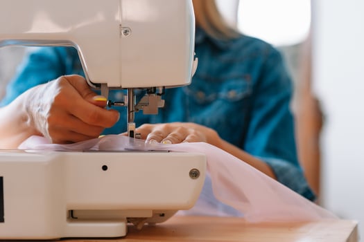 sewing machine, pink fabric and women's hands photo