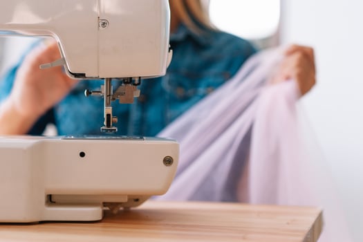 sewing machine, pink fabric and women's hands photo