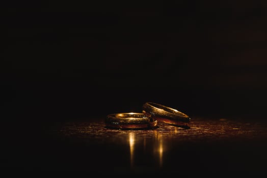 Beautiful wedding gold rings on dark background photo