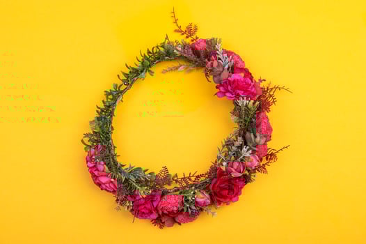 Colorful artificial flowers wreath isolated on yellow photo