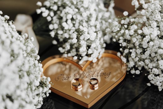 A heart-shaped box with two rings inside and a watch on top. Concept of love and commitment photo