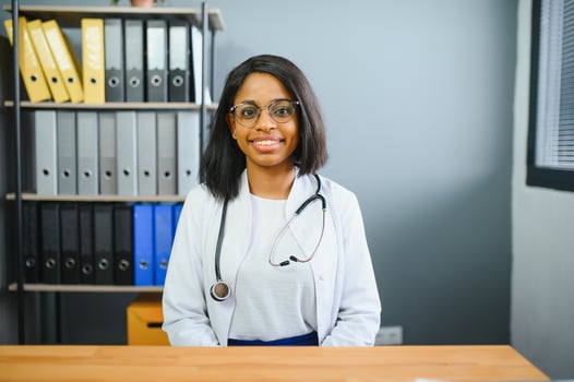 Portrait Of Smiling Female Doctor Wearing White Coat With Stethoscope In Hospital Office. photo