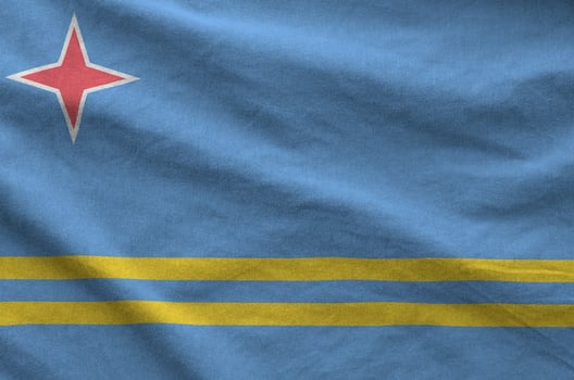 Aruba flag depicted on folded wavy fabric of old cloth photo