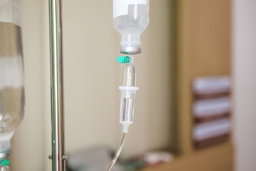 Close up medical intravenous IV drip in hospital background photo