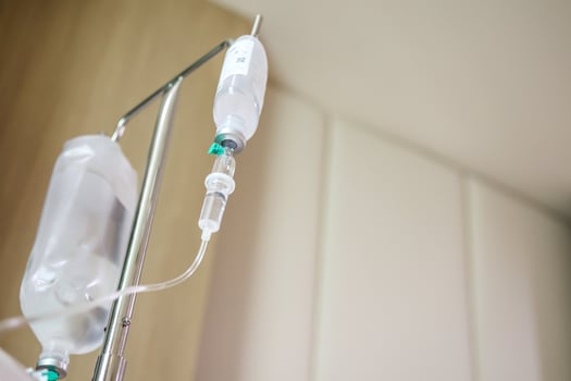 Close up medical intravenous IV drip in hospital background photo