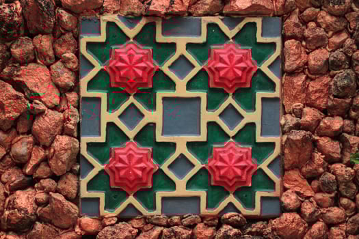 Colorful Clay tile art with stone wall background photo