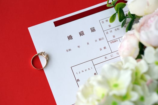 Japanese marriage registration blank document and wedding proposition ring and flowers on table photo